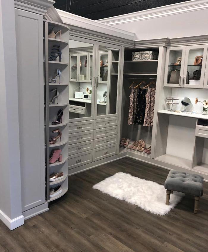 Custom walk-in closet with wood-tone cabinets and hanging